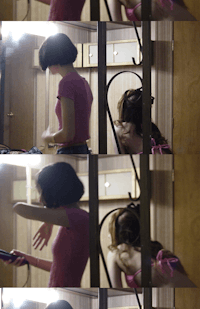a woman is brushing her hair in a mirror