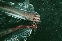 a person's hand is covered in blood