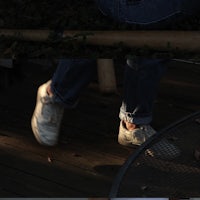 a person is standing on a wooden deck with a baseball bat
